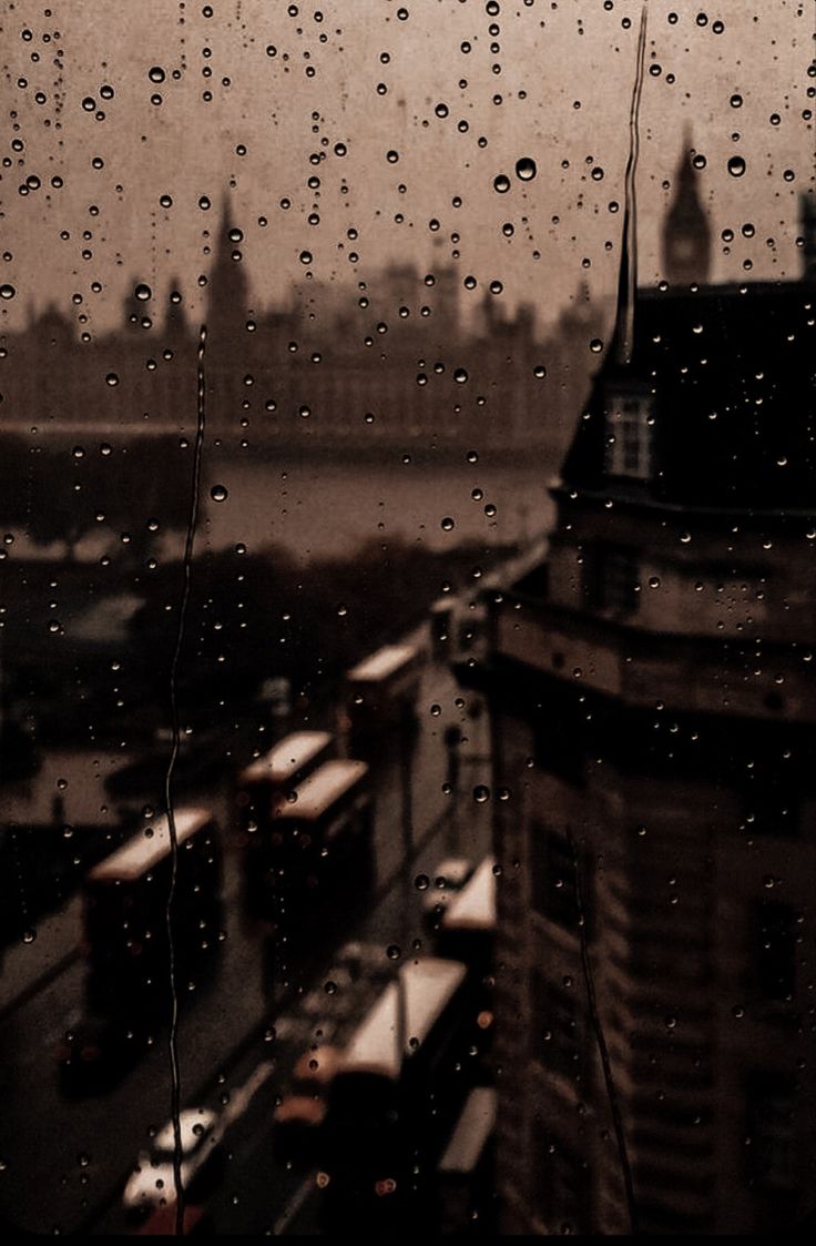 rain drops on a window with buildings in the background