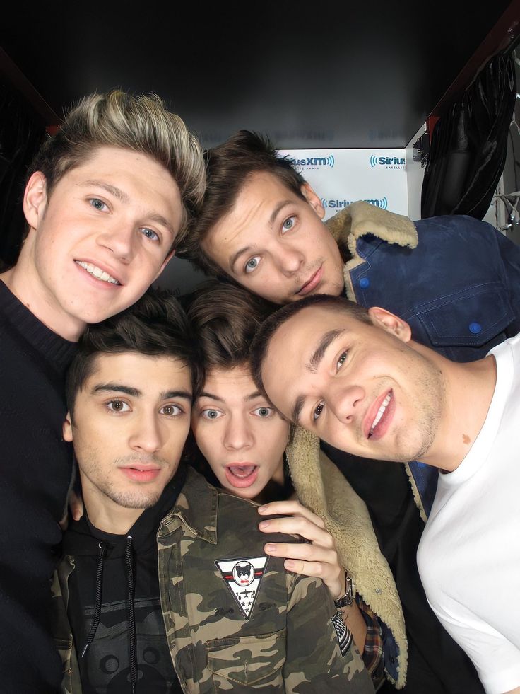 four young men are posing for the camera with one man's hand on his shoulder