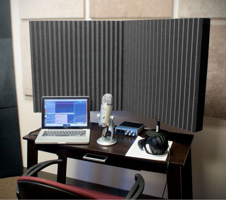 a laptop computer sitting on top of a desk next to a microphone and headphones