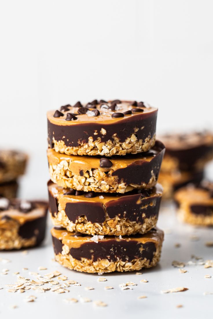 chocolate and peanut butter granola cookies stacked on top of each other with oats scattered around them