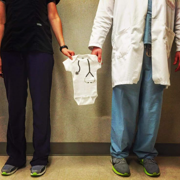 two doctors standing next to each other holding shirts