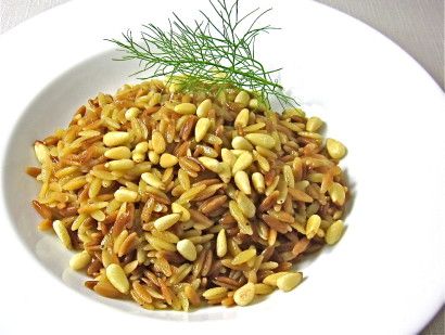 a white plate topped with rice and pine nuts