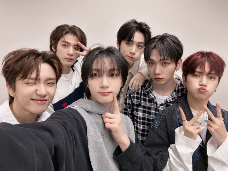 the group of young men are posing together for a photo with their fingers in the air