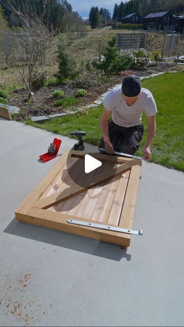 a man working on an outdoor table made out of wood