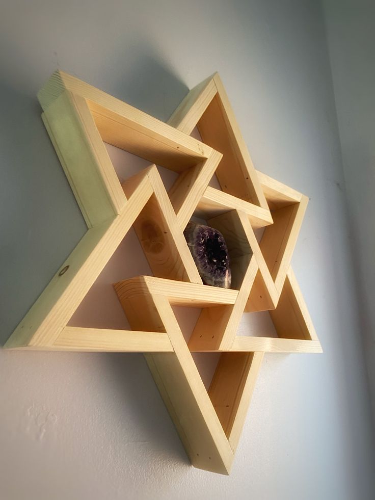 a wooden shelf with an object in the middle on it's side hanging from a wall