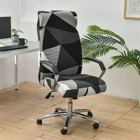 a black and white office chair sitting on top of a hard wood floor next to a computer desk