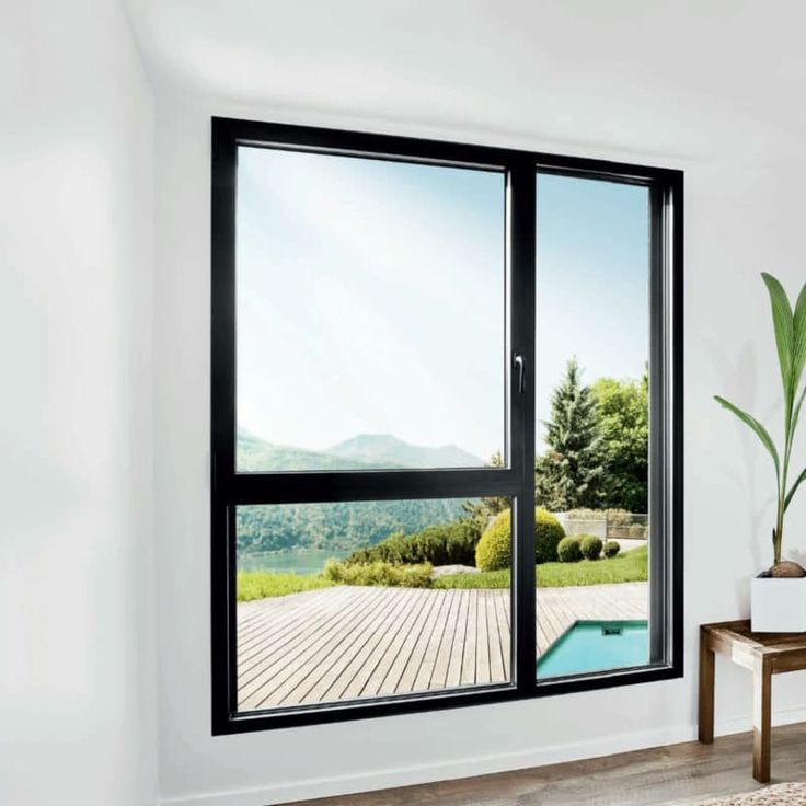 an empty room with a large open window overlooking a pool and mountains in the distance