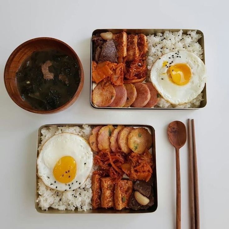 two trays filled with different types of food next to utensils and spoons