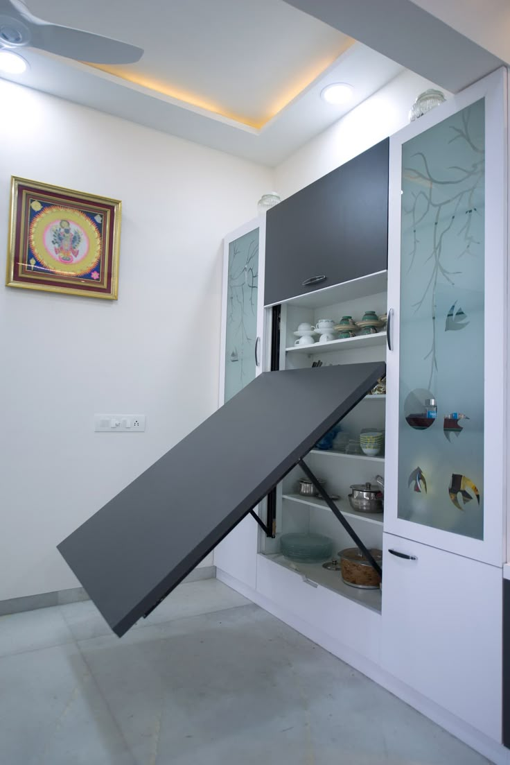 an open cabinet with shoes in it and a ceiling fan hanging from the ceiling above