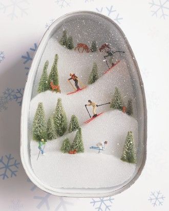 an ornament with skiers and trees in the snow on it's side