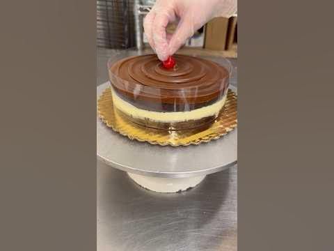 a person is decorating a cake with chocolate frosting