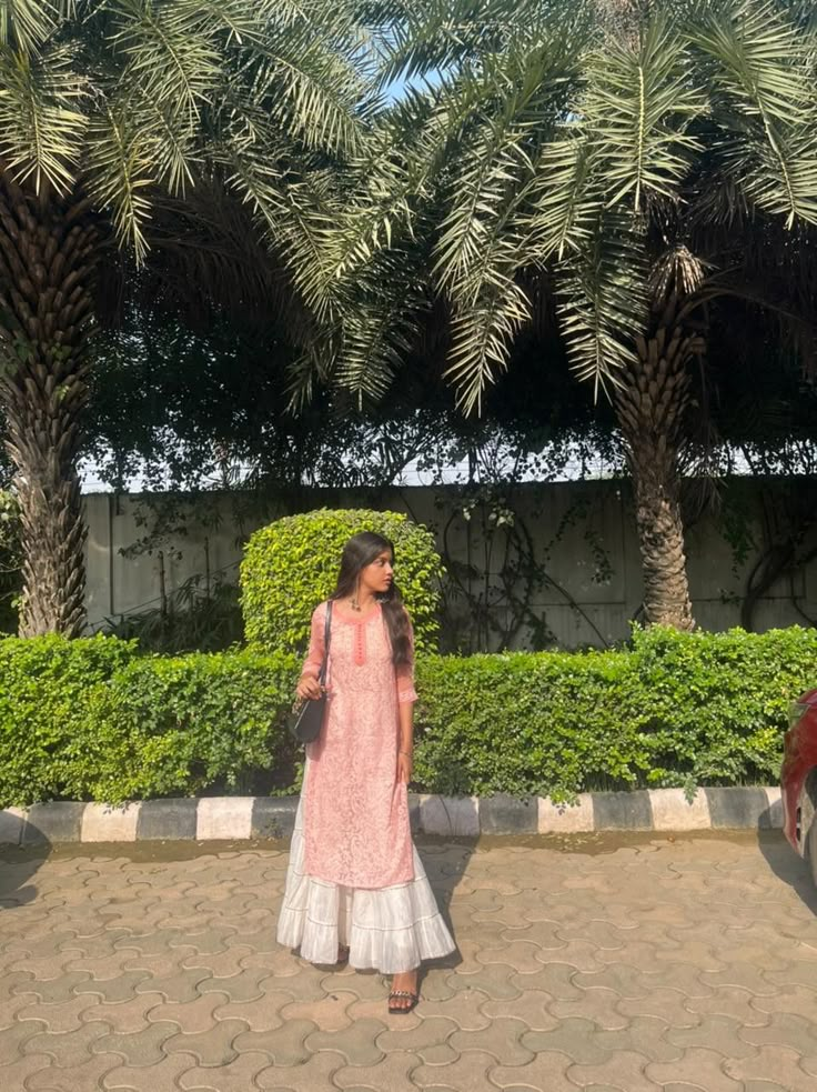 A girl wearing pink chicken kurti with white sharara standing in the sun. Chicken Sharara Suit, Pink Chicken Kurti, Pink Kurti Aesthetic, Pink Kurti Outfit Aesthetic, Chicken Clothes Kurti, White Plazo With Kurti, White Kurti Outfit, Pink Kurti Outfit, Chicken Kurti Designs