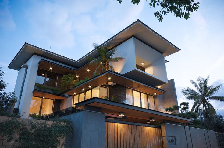 a large modern house with lots of windows and plants on the roof, along with palm trees