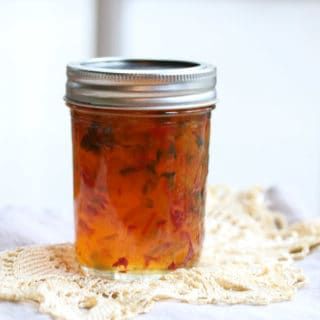 a glass jar filled with food sitting on top of a doily covered table cloth