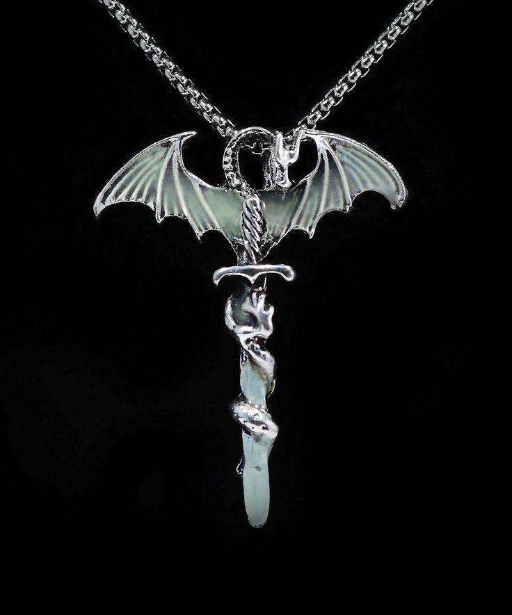 DRAGON SWORD PENDANT GLOW in the DARK Silver Dragon Pendant necklace ☆ Dragon Gift for Her or Him ☆ Birthday Gift  ☆ COSPLAY Accessory ☆ Halloween Costume     Accessory ☆ Quality detailed Dragon    is made of stainless steel    with glow in dark    resin in wings and sword tip ☆ Dragon tail is wrapped around     the Excalibur sword. ☆  Dragon measures 1.5 inches wide    by 2 inches tall or 40mm by 50mm. ☆ Strung onto a 2 mm wide QUALITY      silver-plated stainless steel     ROUNDED BOX CHAIN     50 cm / 19.7 inches in length     with lobster clasp. ☆ ECO-PACKAGING:    In Black gift box and Eco    reusable gift bag. ☆  USA SHIPPING same day as ordered to      USA customers . ☆  Be Dragon Magical and Glow! Dragon Jewelry Aesthetic, Dragon Pendant Necklaces, Dragon Rings, Dragon Scale Necklace, Silver Dragon Necklace, Dragon Bracelet, Dragons Gift, Princess Jewelry, Tooth Necklace