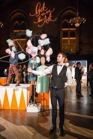 a man standing on top of a wooden floor in front of a table with balloons