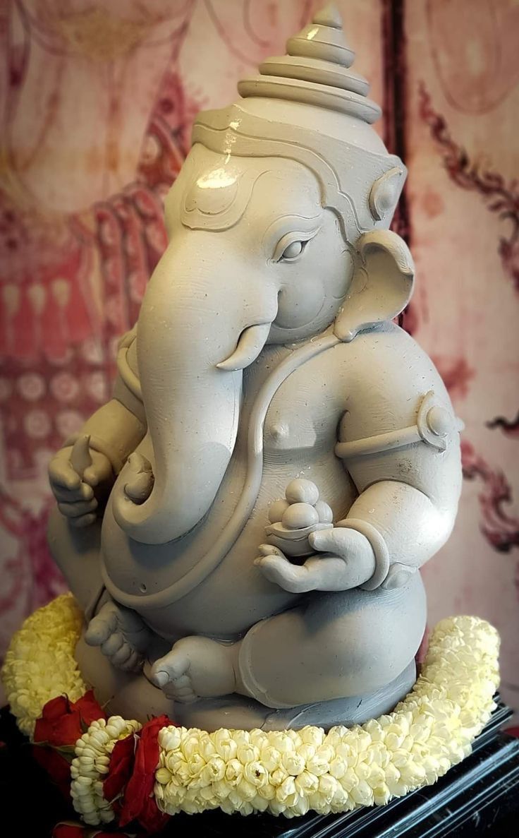 an elephant statue sitting on top of a table next to a red and white wall