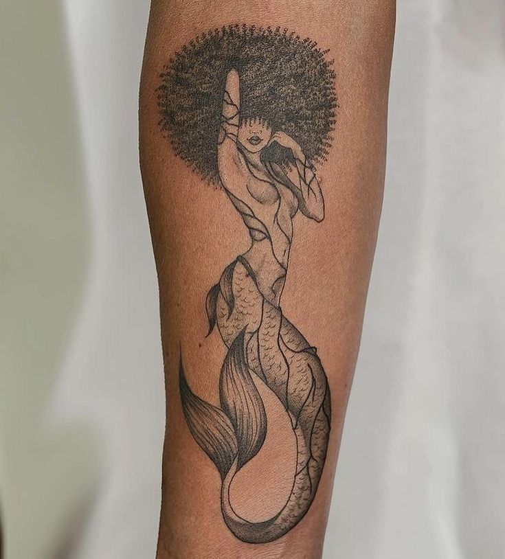 a black and white photo of a mermaid tattoo