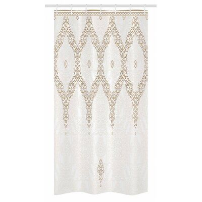 a white shower curtain with an intricate design on it's side and gold trim