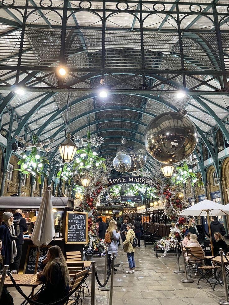 the inside of an indoor market with lots of tables and umbrellas on it's sides