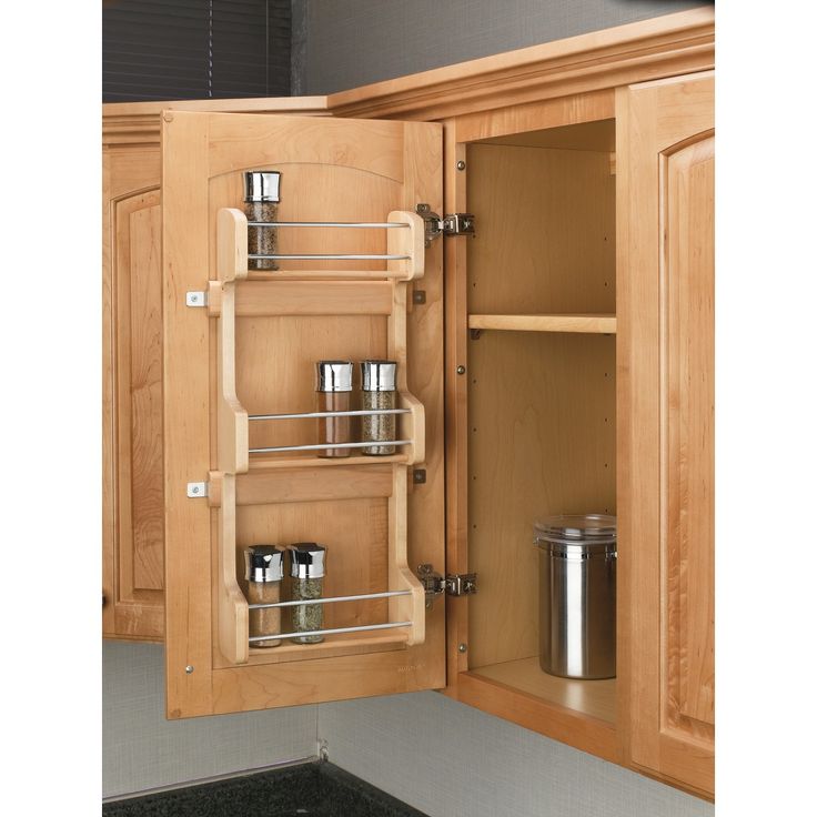 an open cabinet door with spice racks in it