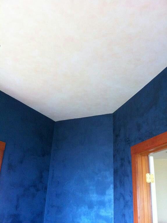 an empty room with blue walls and wood trimmings on the ceiling is shown