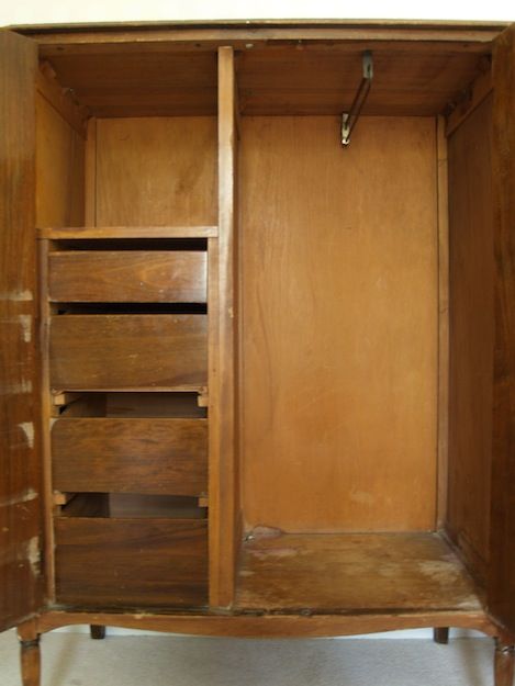 an empty closet with wooden shelves and drawers