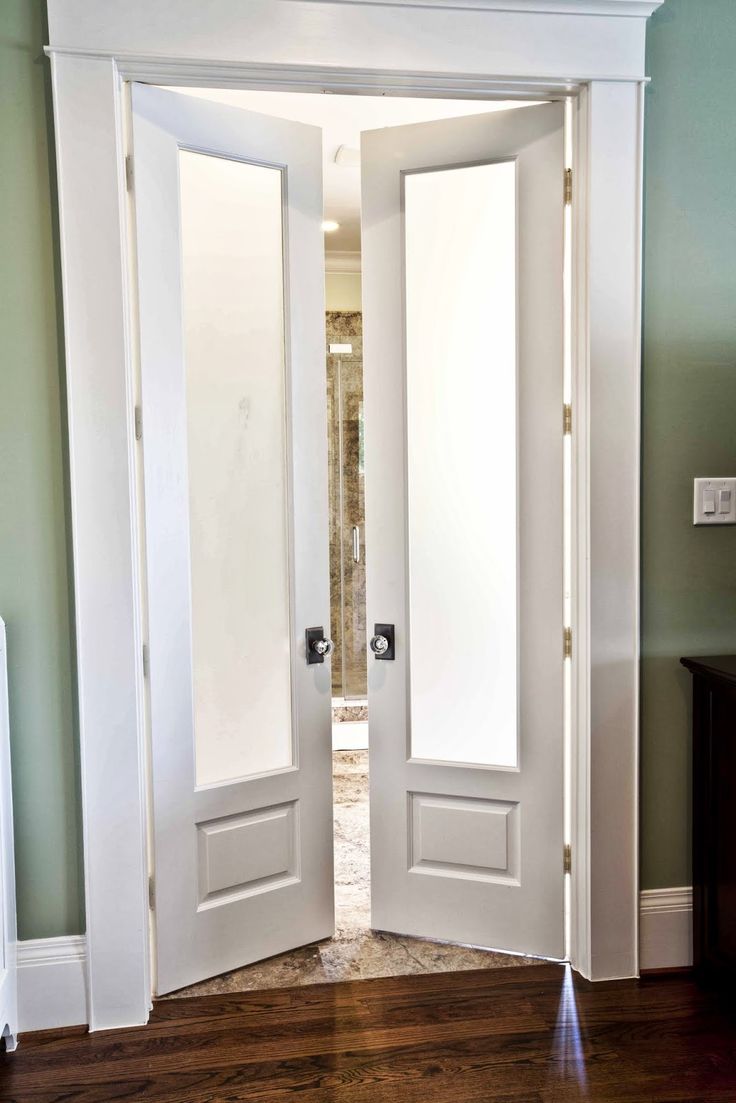 two white doors open in an empty room