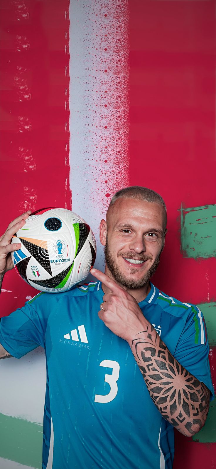 a man holding a soccer ball in front of a red and white wall with water droplets on it