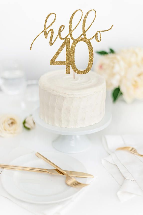 a cake with the number 40 on it and some gold utensils next to it