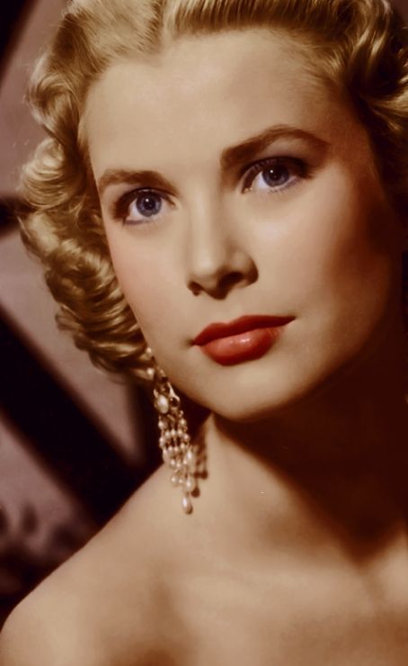 an old photo of a woman with blue eyes and blonde hair, wearing large earrings