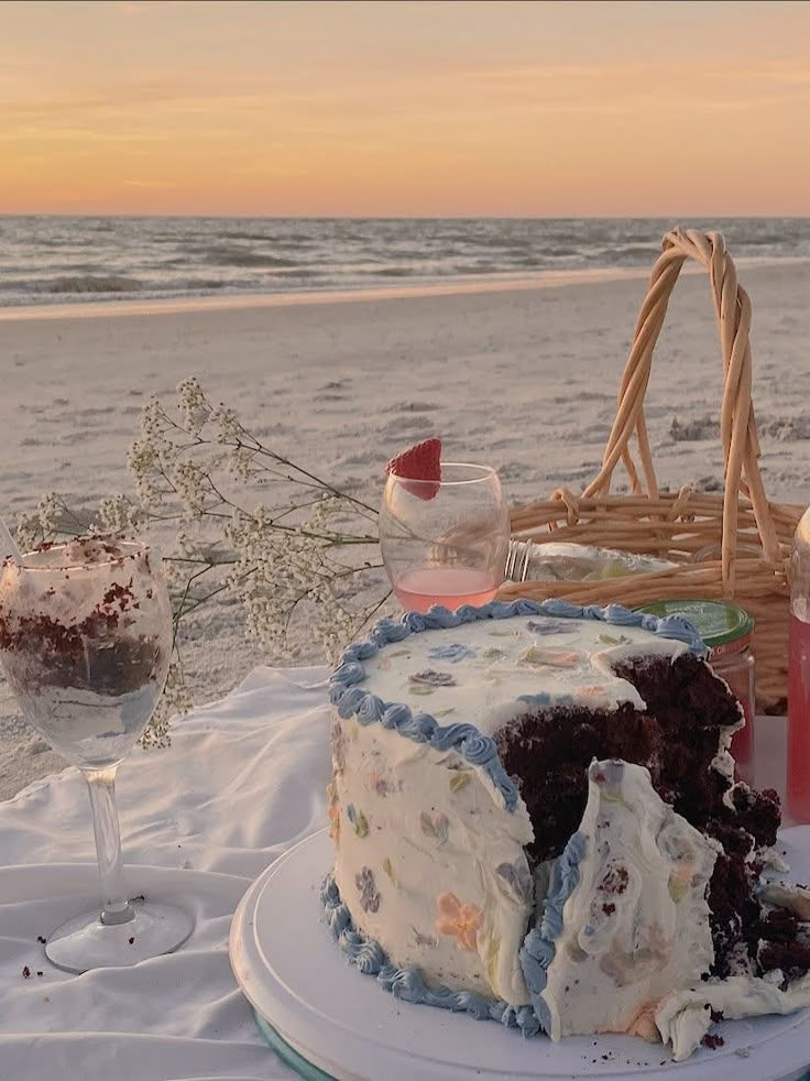 a cake sitting on top of a white plate next to a basket filled with food