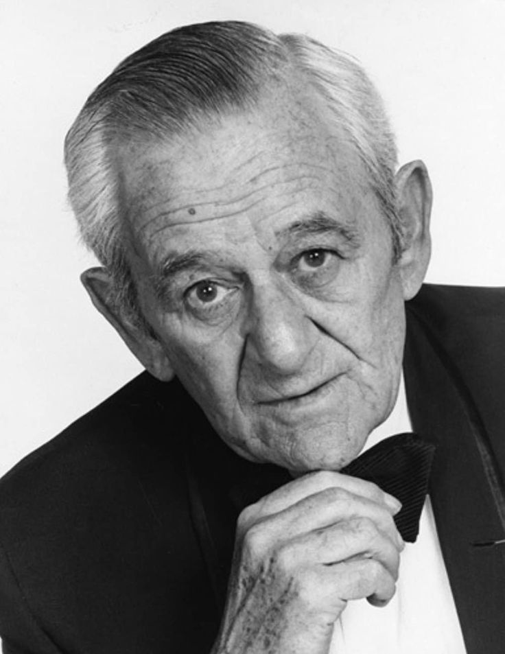 an older man in a tuxedo poses for a photo with his hand on his chin