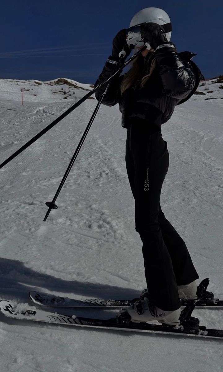 a person on skis in the snow with their back turned to look like she's about to go skiing