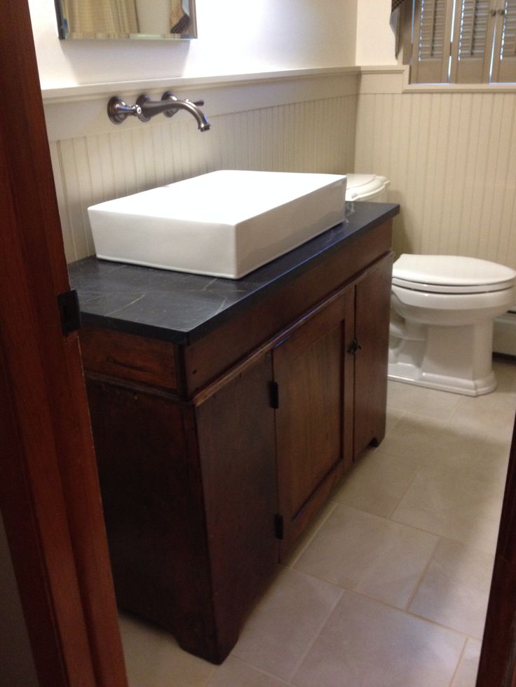 a white toilet sitting next to a sink in a bathroom