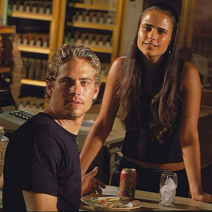 a man and woman sitting at a table with food