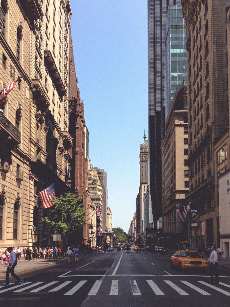 an empty city street with tall buildings and people