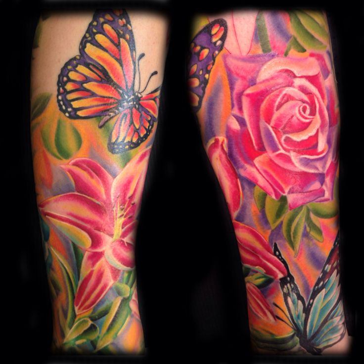 a woman's legs with colorful tattoos and flowers on them, including a butterfly