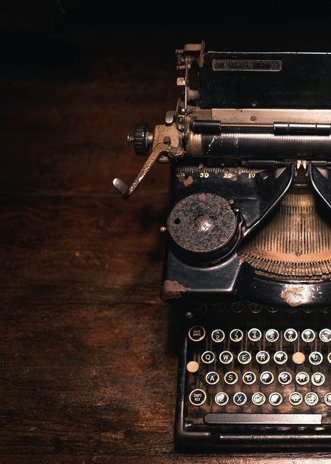 an old fashioned typewriter sitting on top of a wooden table