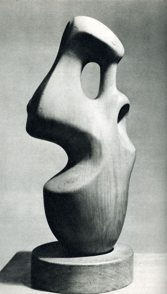 a black and white photo of a sculpture on a pedestal with the shape of a face