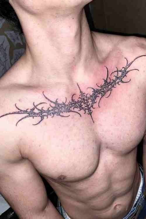 a man's chest with barbed wire tattoo on his left side and right breast