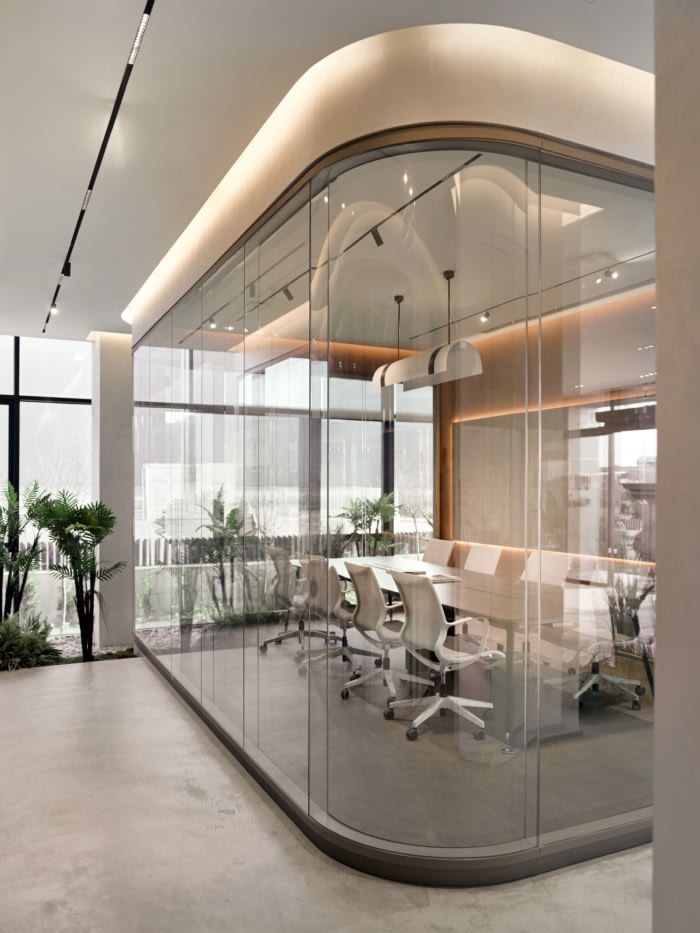 an office with glass walls and white chairs