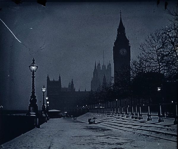 the big ben clock tower towering over the city of london in black and white at night