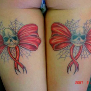 two tattoos on both legs with skulls and bows in the shape of bowknots