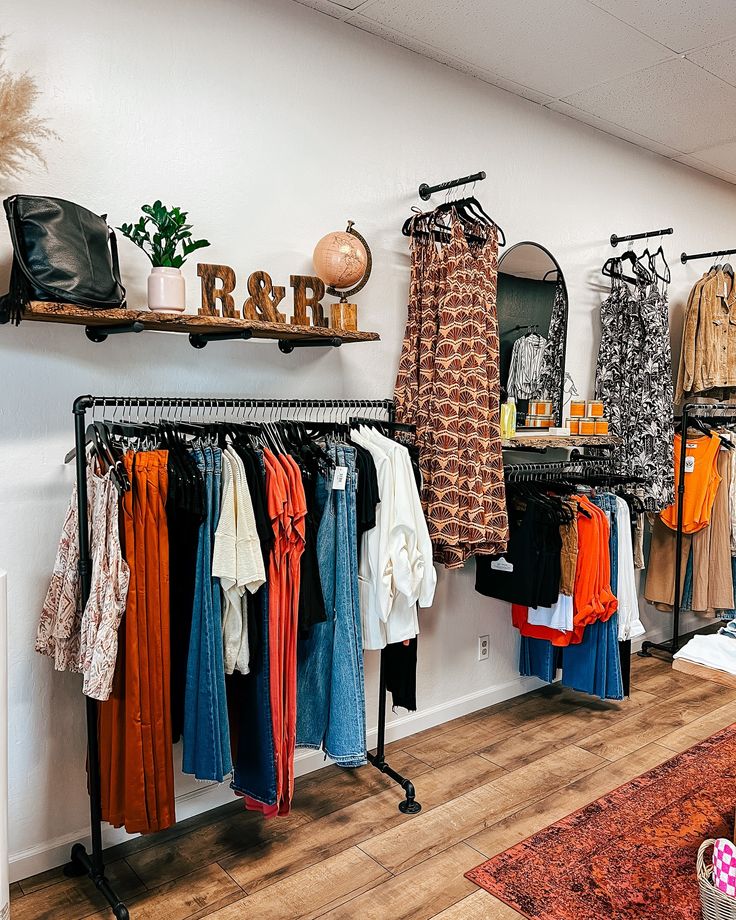 a clothing rack with clothes hanging on it and other items in the background, along with an area rug