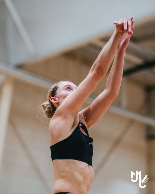 a woman in black top and white shorts playing with a volleyball ball at indoor court