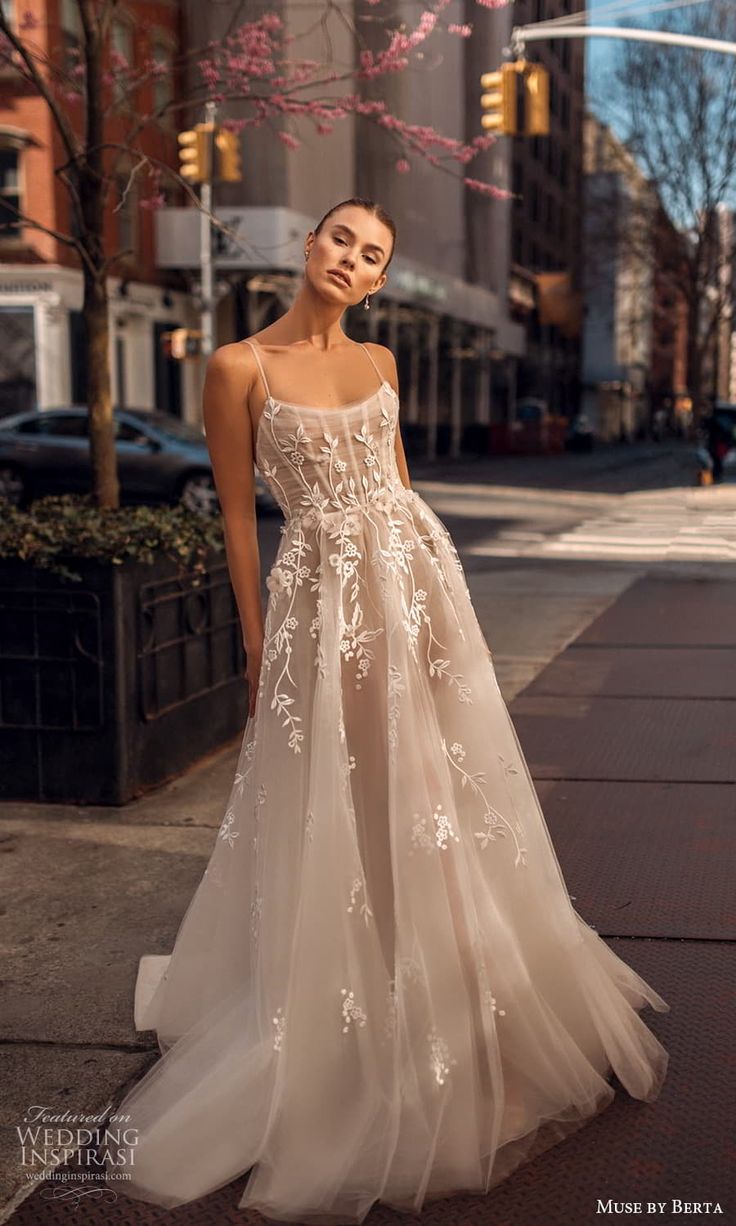 a woman in a wedding dress standing on the sidewalk