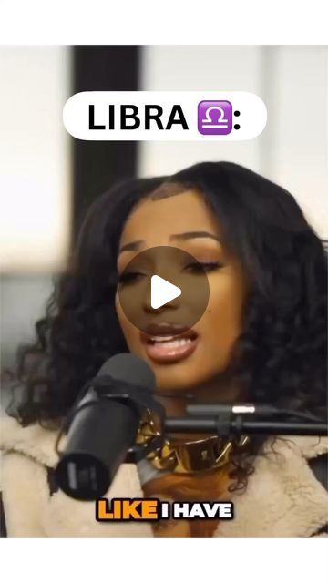 a woman holding a microphone in front of her face with the words libra on it