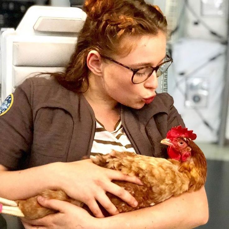 a woman holding a chicken in her arms