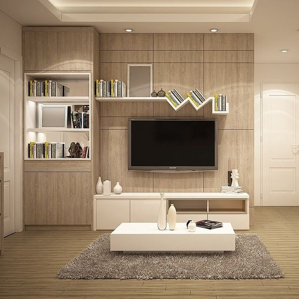 a modern living room with white furniture and bookshelves on the wall, along with a large flat screen tv